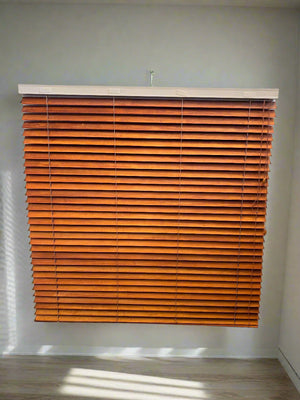 Wooden blinds on a window with a neutral wall background