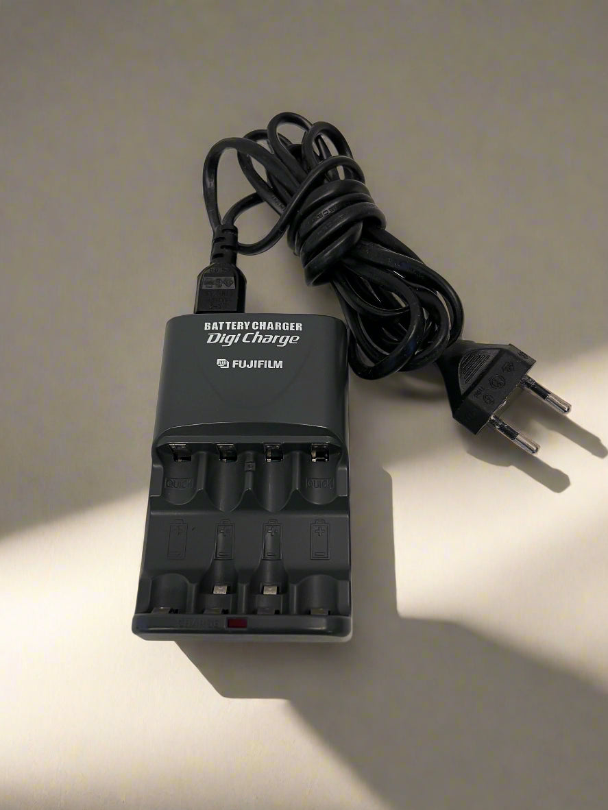 Fujifilm battery charger with power cord on a neutral background