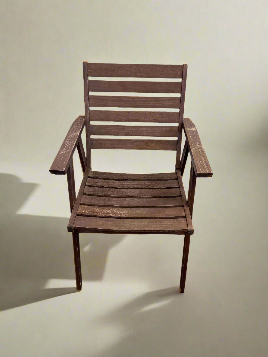 Wooden chair against a white brick wall.