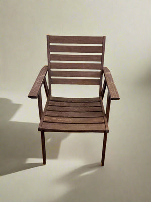 Wooden chair against a white brick wall.