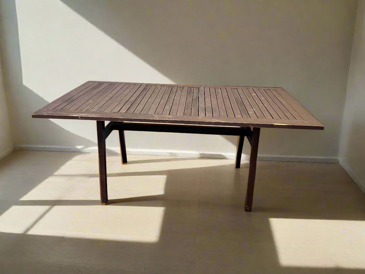 Wooden table against a white brick wall