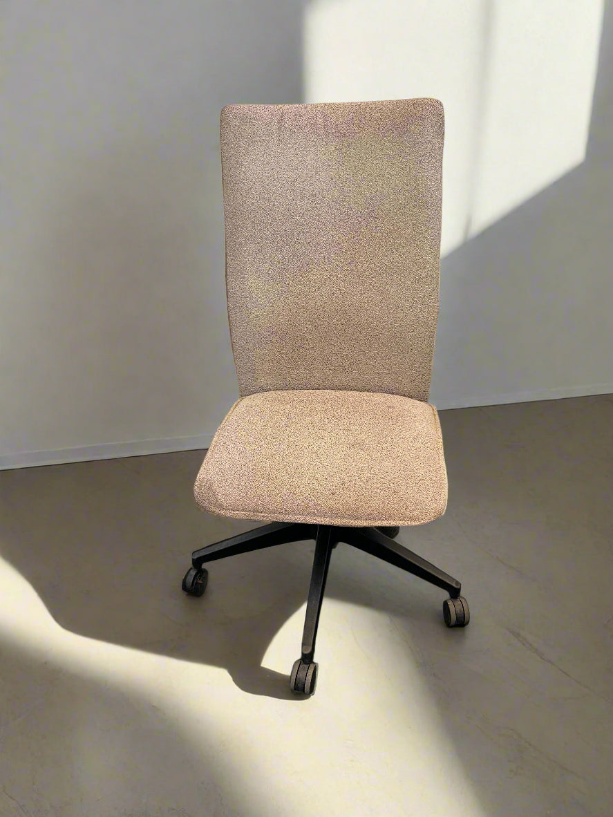 Beige office chair with a high backrest on a plain floor.