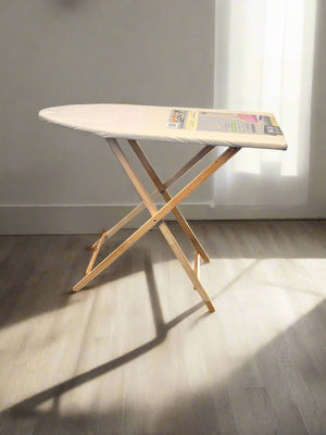 Foldable ironing board with a white surface against a neutral wall.