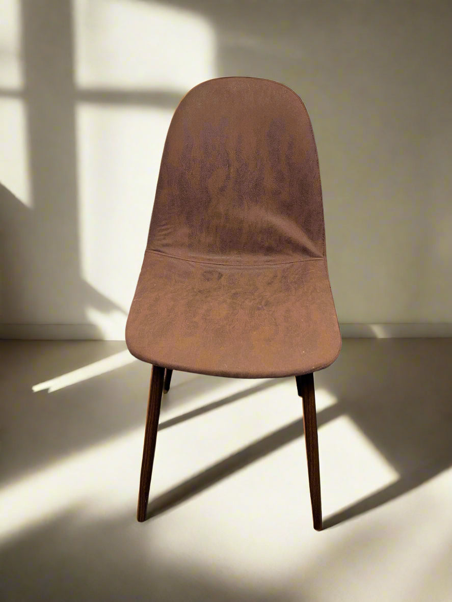 A vintage brown dining chair with mid-century design, featuring a faux leather seat and wooden legs.