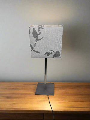 Table lamp with a decorative lampshade on a wooden surface