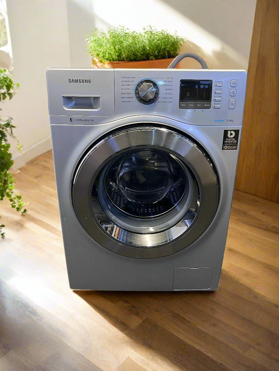 Samsung washing machine on a wooden floor with plants in the background