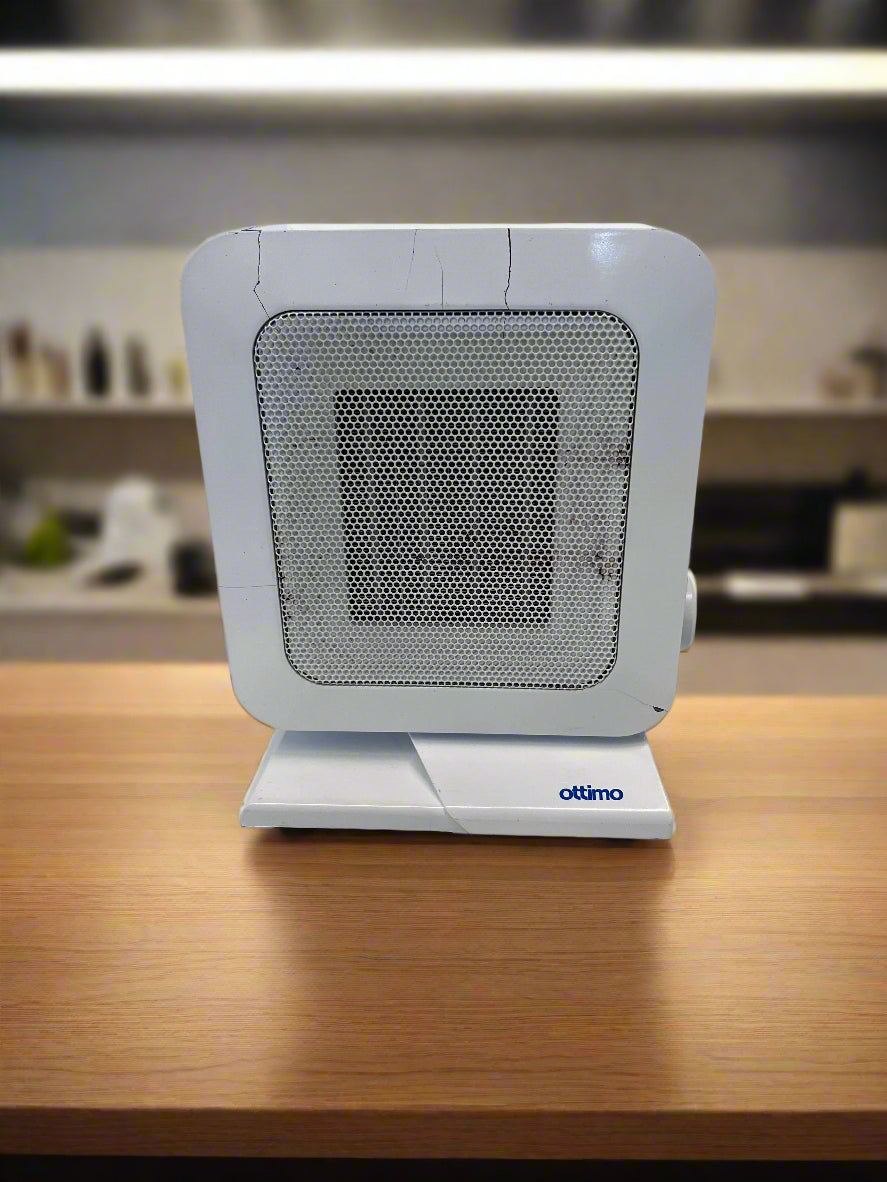 Small white fan heater on a wooden surface with a blurred kitchen background
