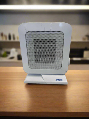 Small white fan heater on a wooden surface with a blurred kitchen background
