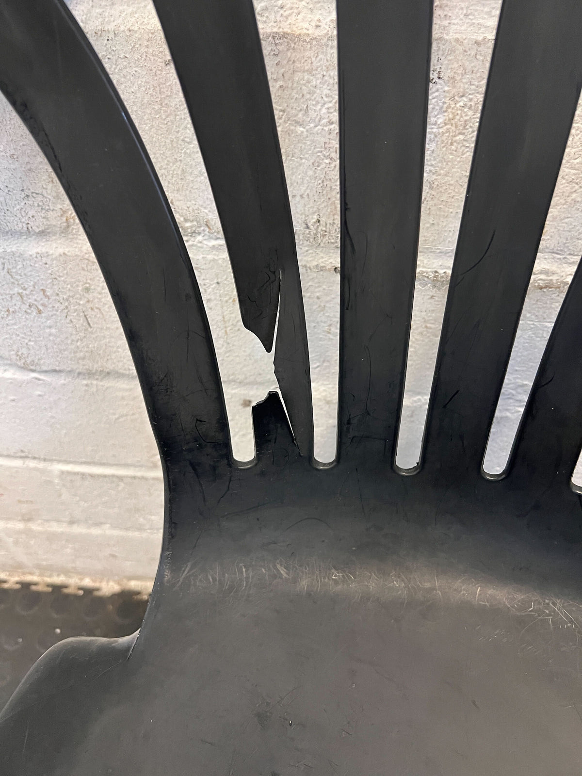 Durable Black Plastic Chair with Minor Scratches