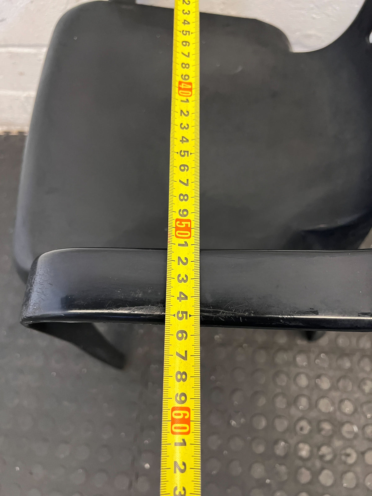 Durable Black Plastic Chair with Minor Scratches