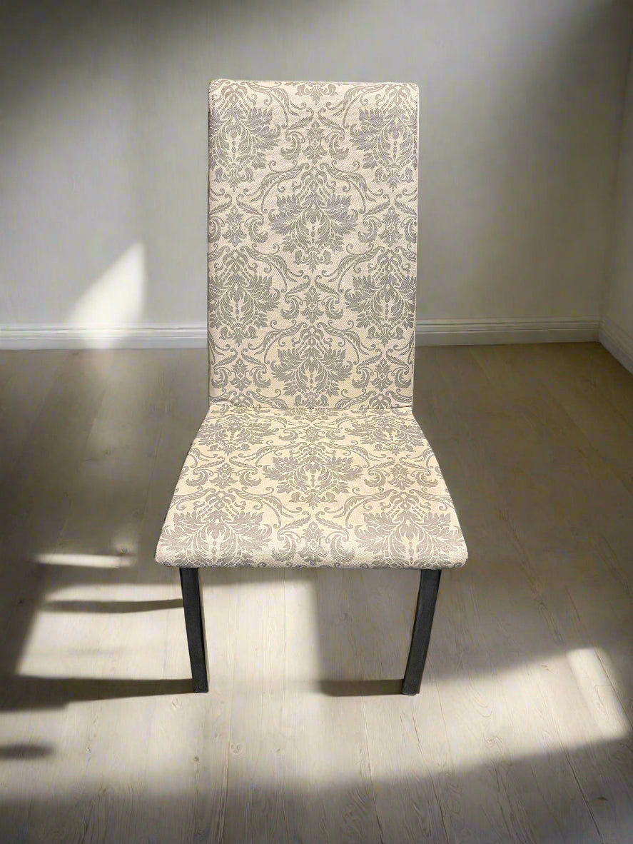 Chair with patterned backrest against a brick wall.