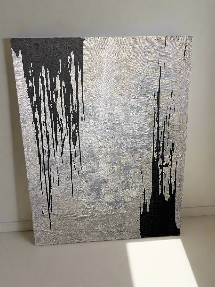 Abstract art piece with black and white paint on a textured gray background