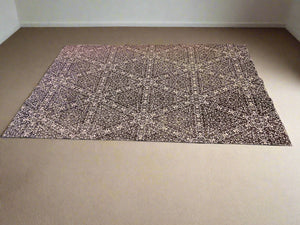 Textured mat on a black surface with a white brick wall background