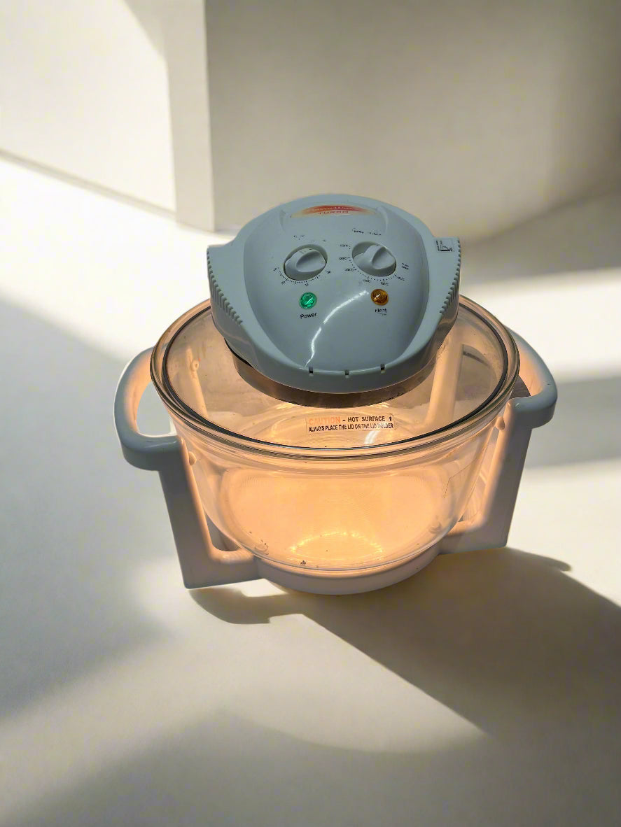 Glass food processor with a white base on a white surface