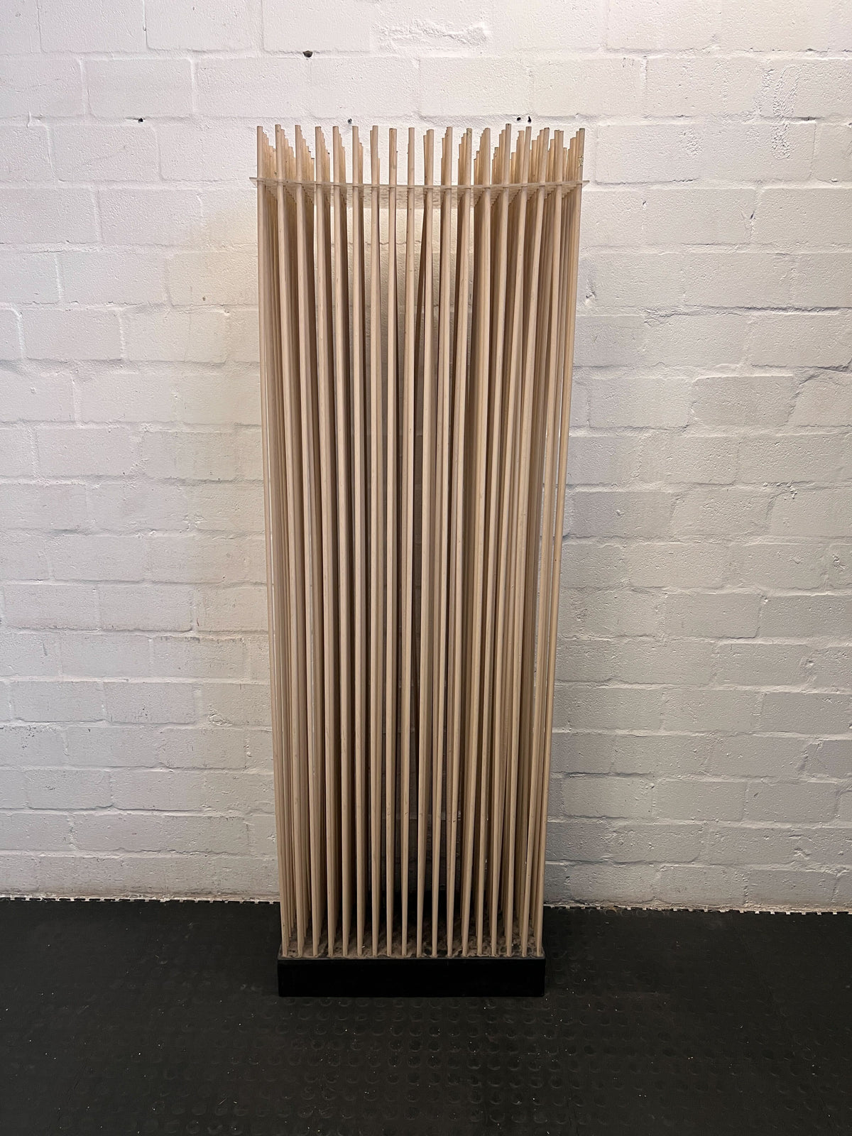 Cardboard standee against a white brick wall