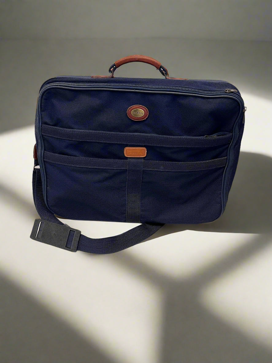 Navy blue suitcase with brown accents on a light gray background
