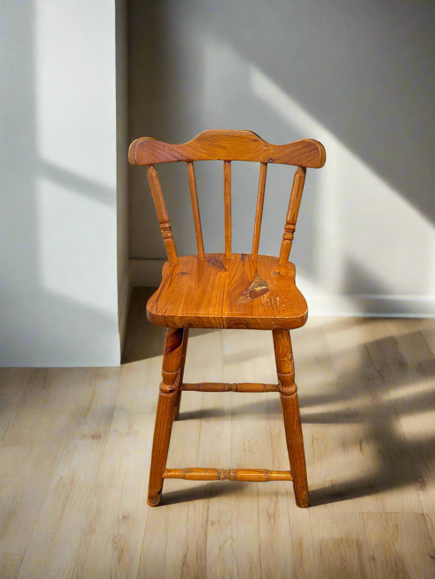 Wooden chair on a wooden floor with a light gray wall in the background