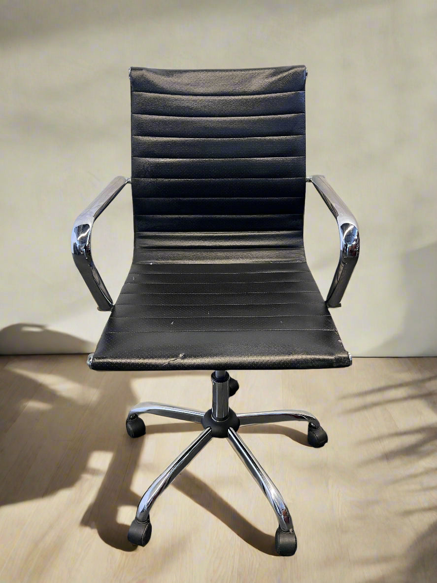 Black office chair with chrome base on a wooden floor.