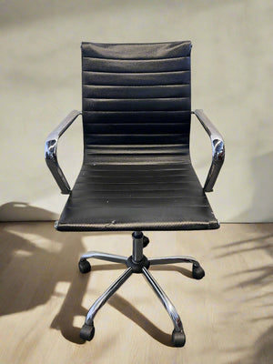 Black office chair with chrome base on a wooden floor.
