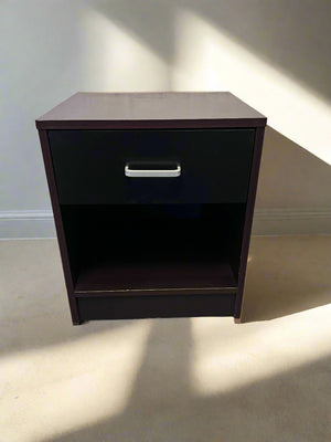 Dark wood nightstand with a single drawer on a light-colored floor.