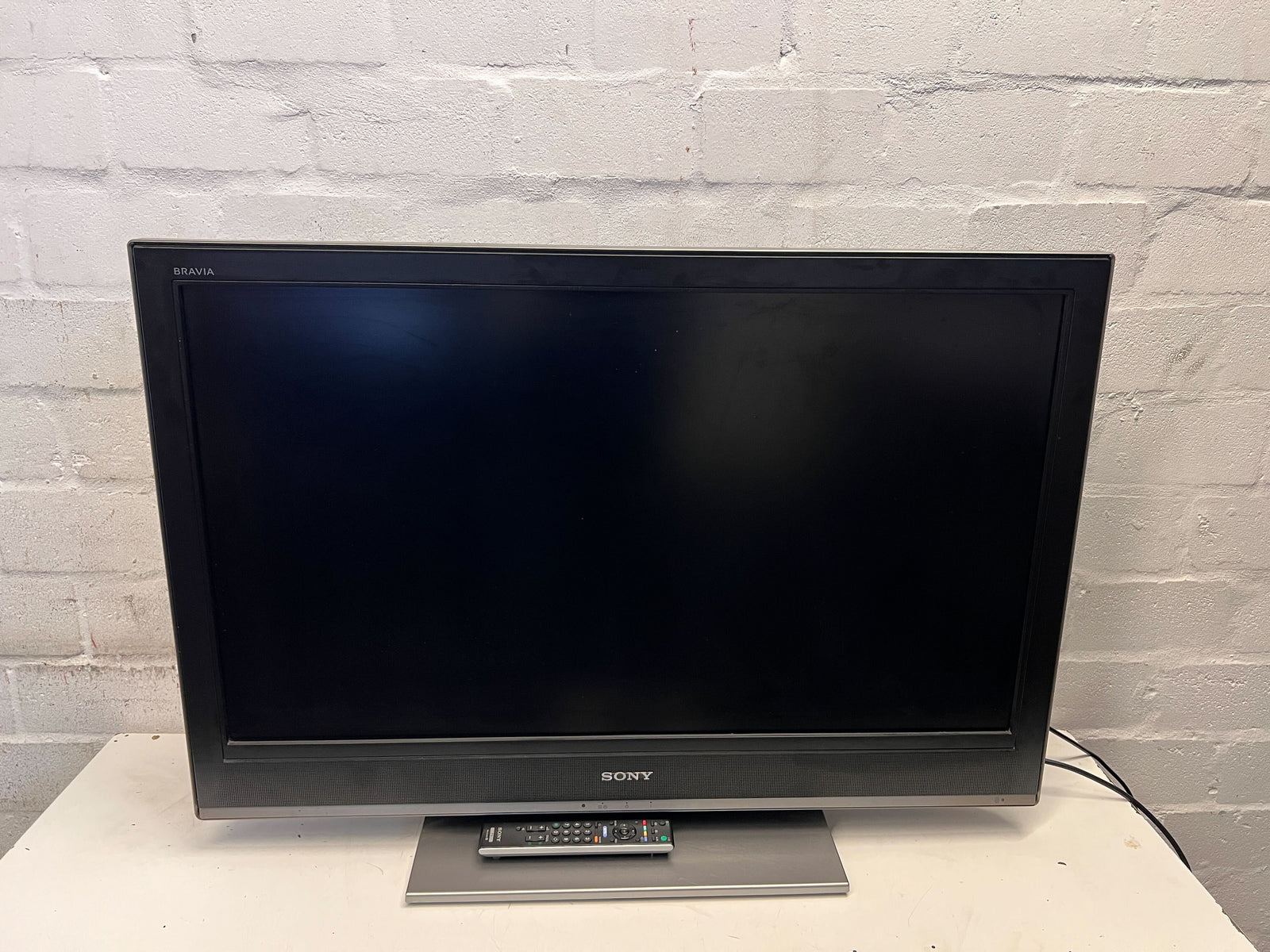 Sony television on a stand against a gray brick wall