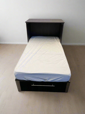 Single bed with a black frame and white mattress on a plain floor.
