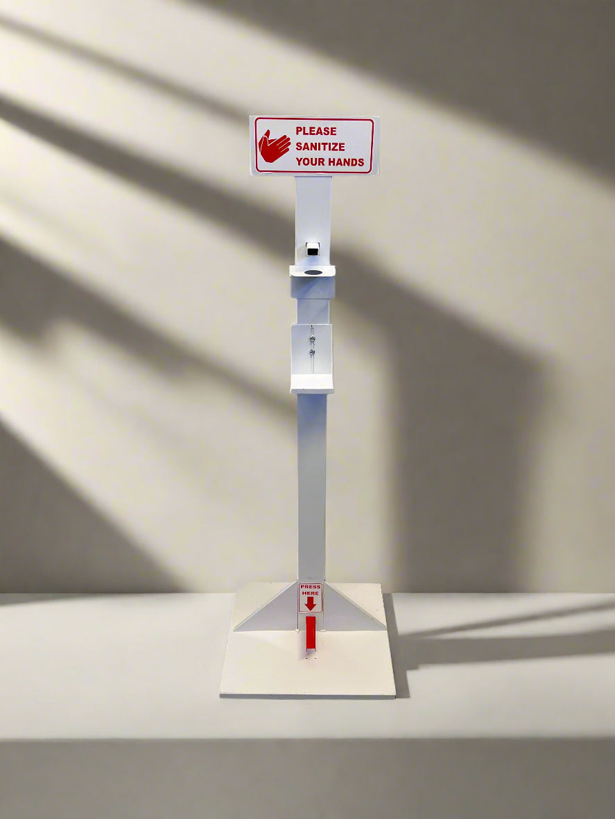 Hand sanitizer station with a sign on a light gray surface.