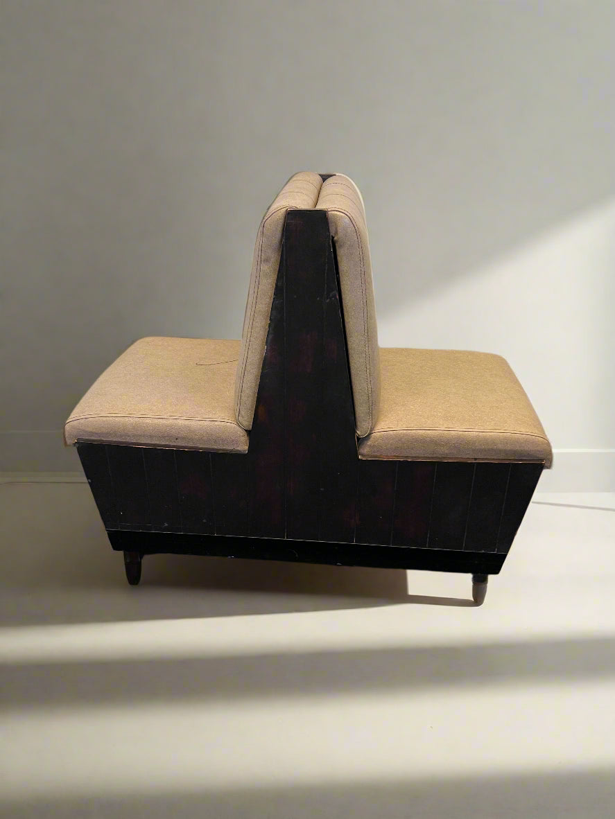 Sectional seating arrangement with beige cushions against a white brick wall.