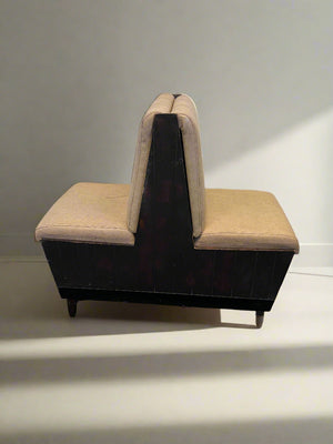 Sectional seating arrangement with beige cushions against a white brick wall.