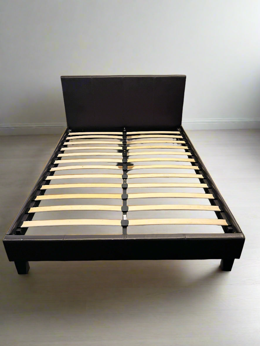 Wooden bed frame with slats on a plain background