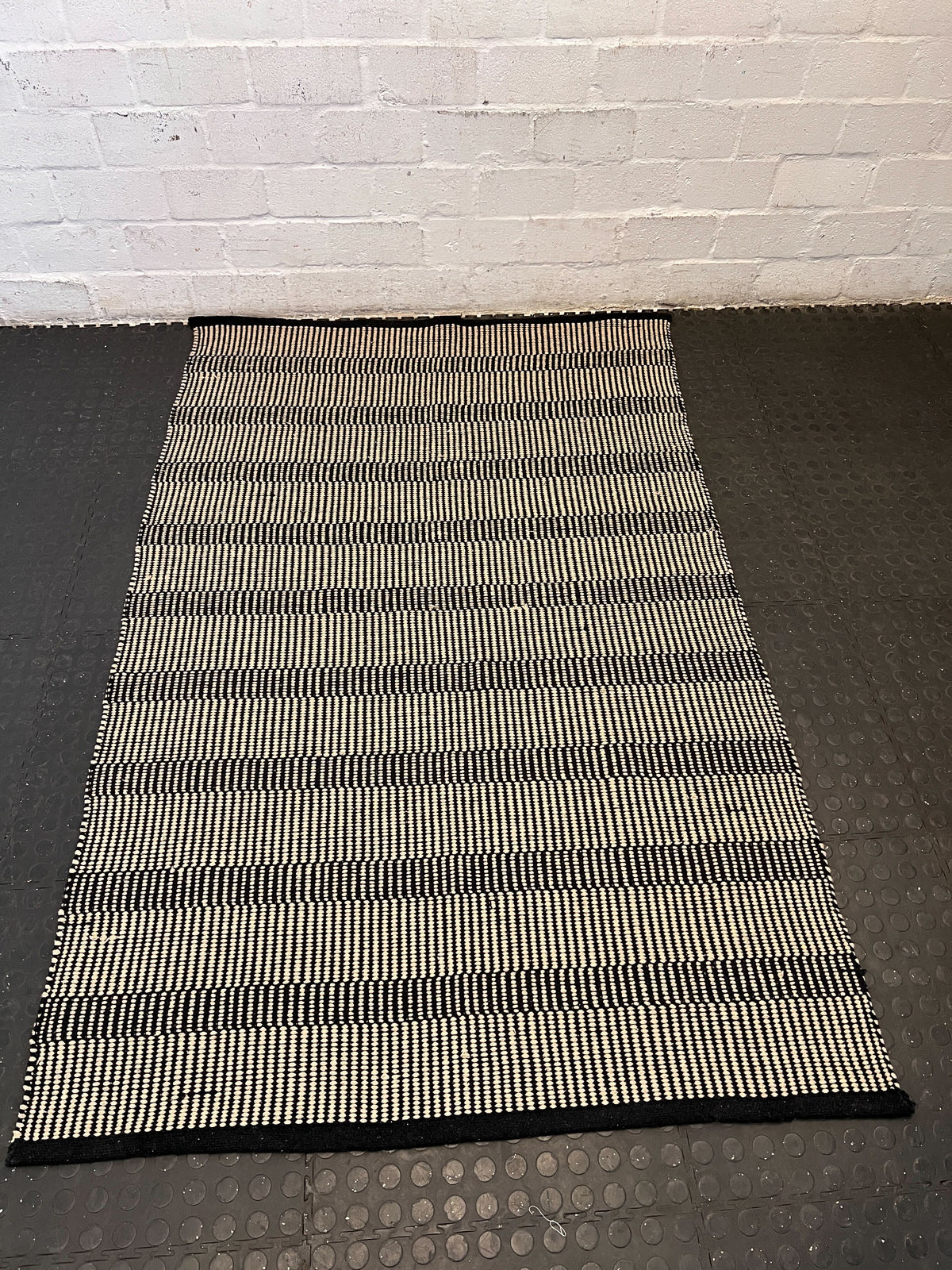 Stylish Black and White Woven Area Rug - Minimalist Design, Slight Wear