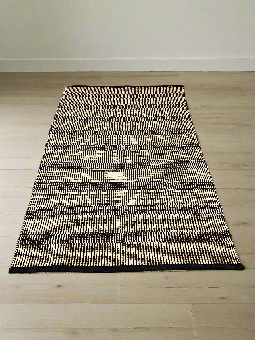 Stylish Black and White Woven Area Rug - Minimalist Design, Slight Wear