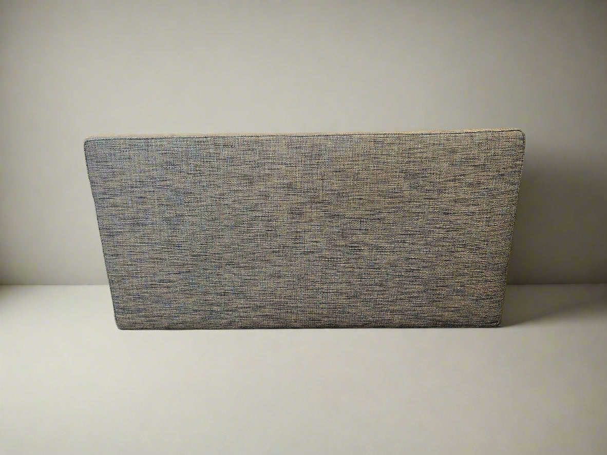 Textured gray cushion on a light surface with a neutral background