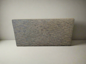 Textured gray cushion on a light surface with a neutral background