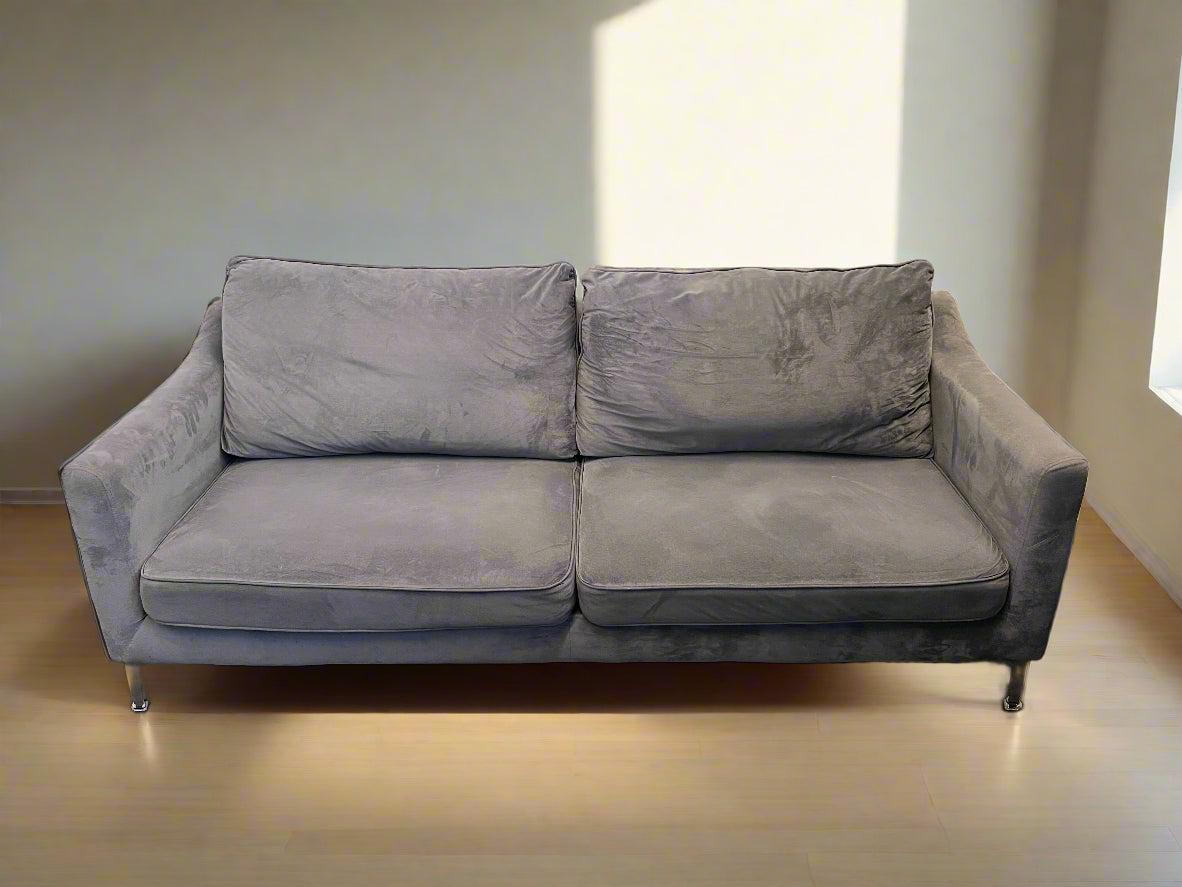 Gray sofa in a room with a light-colored floor and wall.