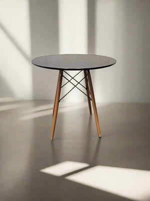 Round table with wooden legs on a neutral background