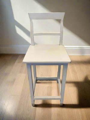 White wooden chair on a wooden floor with a white wall background