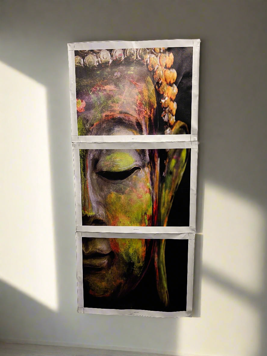 Three framed artworks of a stylized face on a white brick wall.