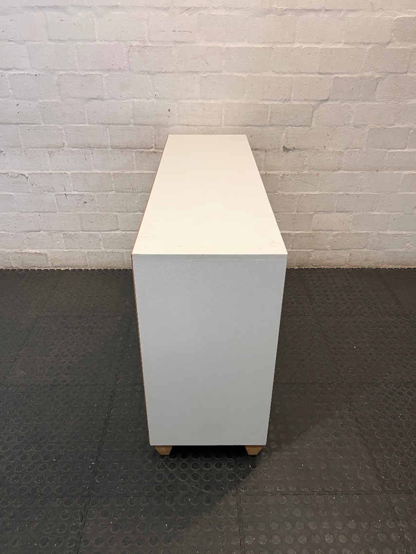 White Storage Cabinet with 4 Drawers and Wood Legs — Small Mark on One Drawer Face