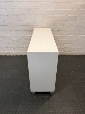 White Storage Cabinet with 4 Drawers and Wood Legs — Small Mark on One Drawer Face