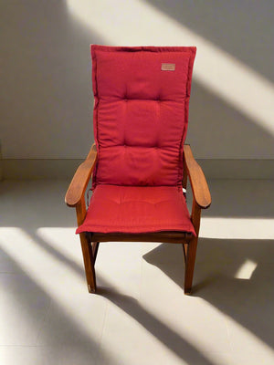 Wooden chair with red cushions on a light floor and wall background