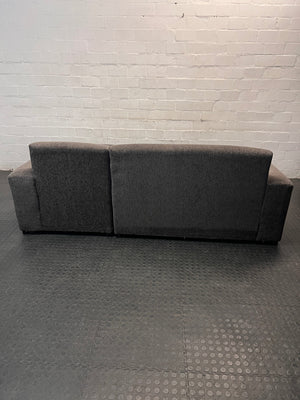 Grey Textured Fabric L-Shape Couch — Damaged and Worn Condition – back view
