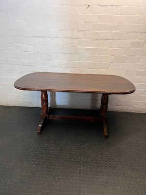 Rounded Brown Timber Dining Table with Pedestal Base — Visible Wear on Tabletop – back view