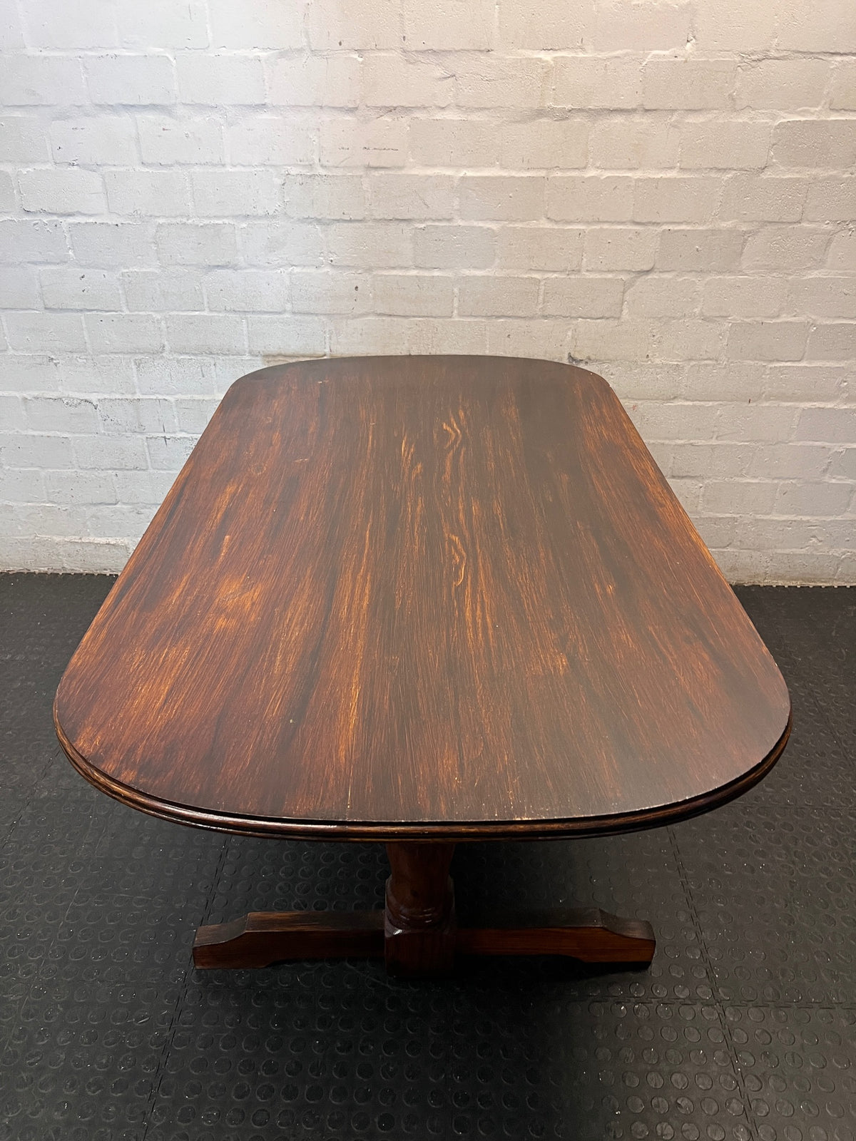 Rounded Brown Timber Dining Table with Pedestal Base — Visible Wear on Tabletop – condition detail