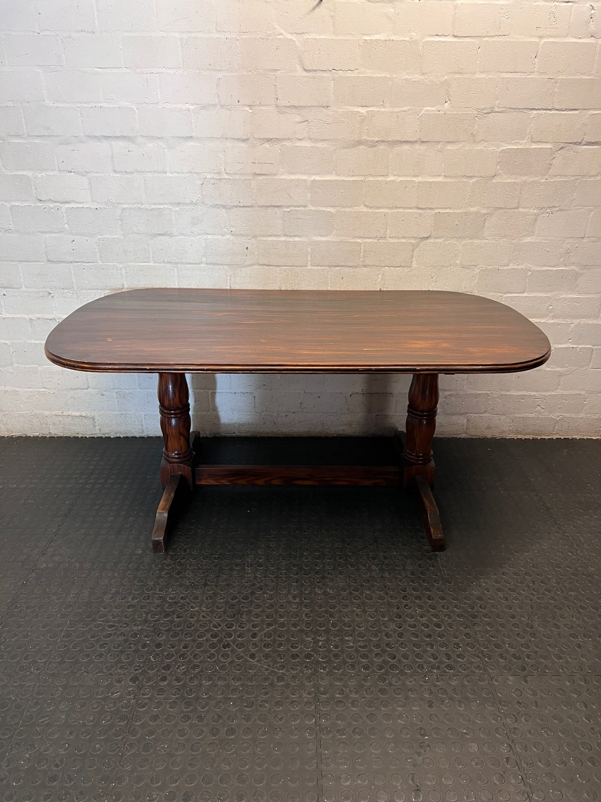 Rounded Brown Timber Dining Table with Pedestal Base — Visible Wear on Tabletop – main front view