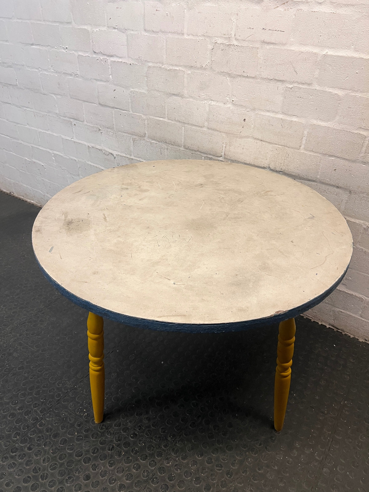Round Yellow Wood Outdoor Table with Blue Trim — Visible Wear and Surface Staining – condition detail
