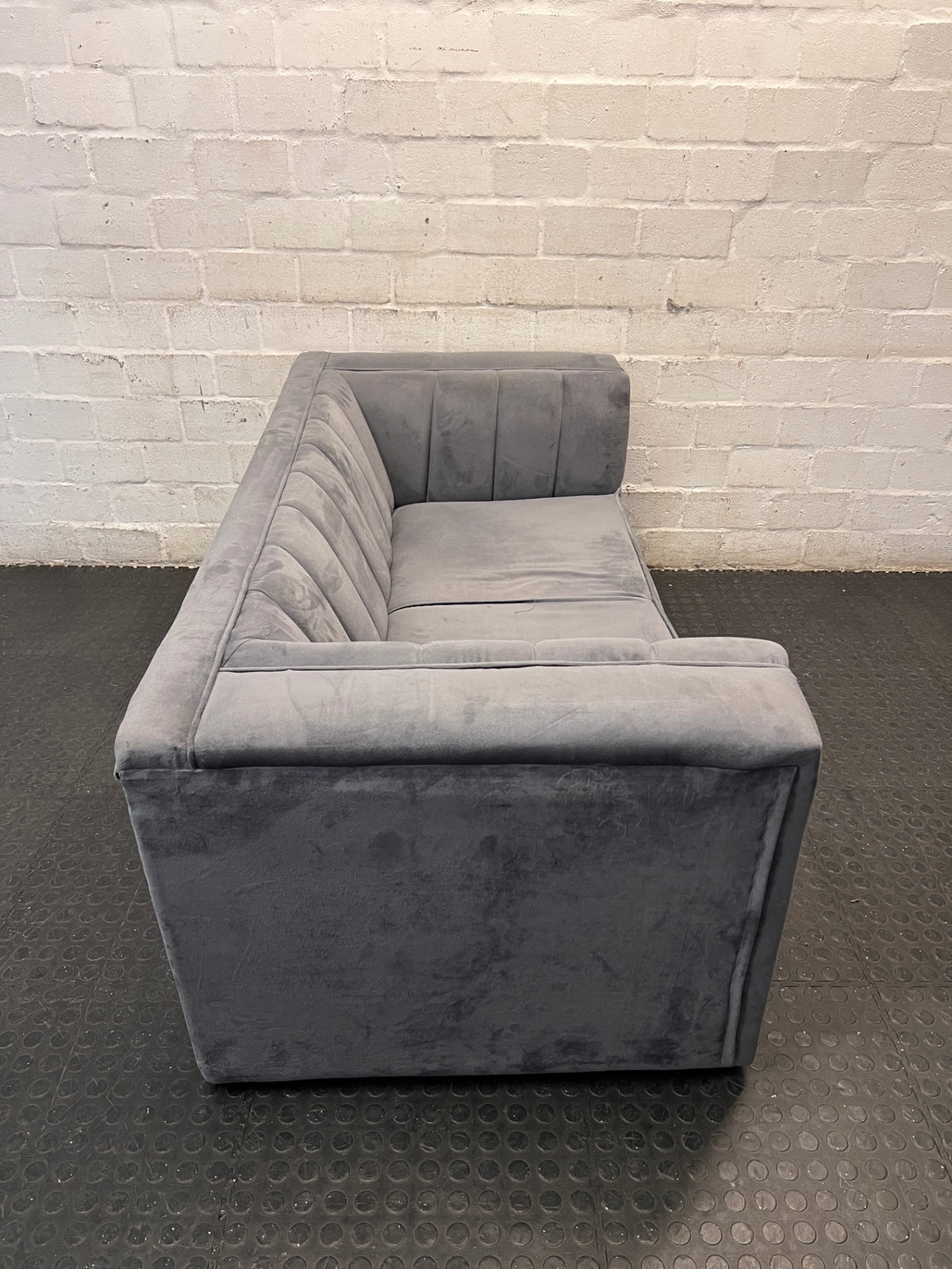 Grey Two Seater Couch with Vertical Stitching — Upholstery Has Wear and Tear – back view