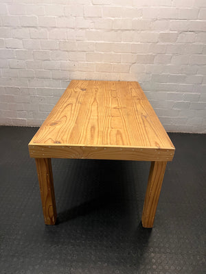 Rustic Oak-Tone Wooden Dining and Work Table — Unfinished Wood with Paint Splatter and Water Rings – back view