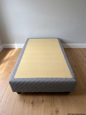 Quilted Grey Upholstered Single Bed Base — Loose Bottom Ring and Well-Used Condition – styled product image