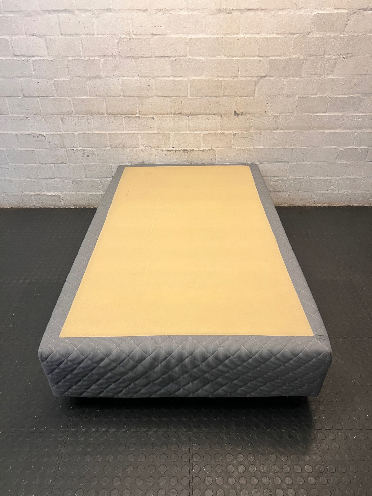 Quilted Grey Upholstered Single Bed Base — Loose Bottom Ring and Well-Used Condition – top view